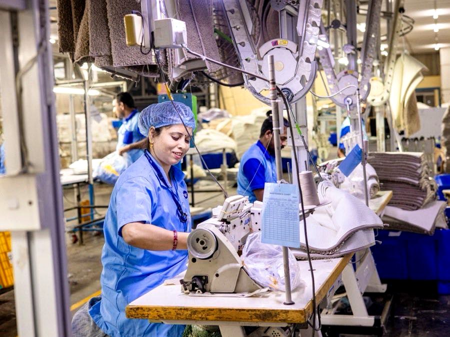 Garment factory workers operating industrial sewing machines