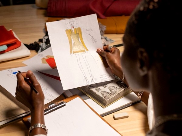 Designer sketching a garment design at a studio desk