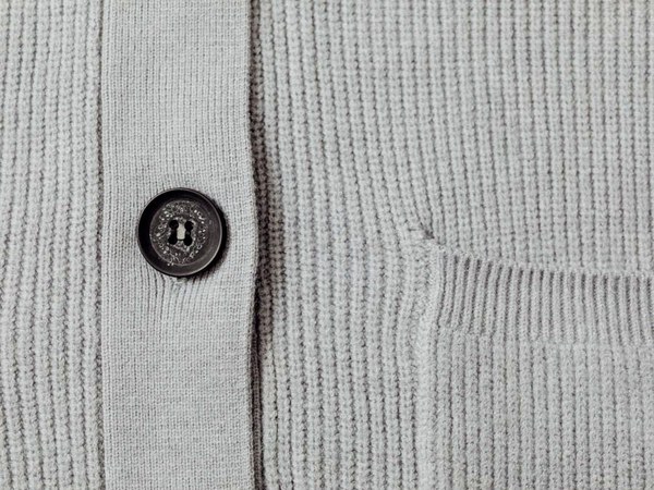 Close-up of a knitted cardigan showing stitch and button detail